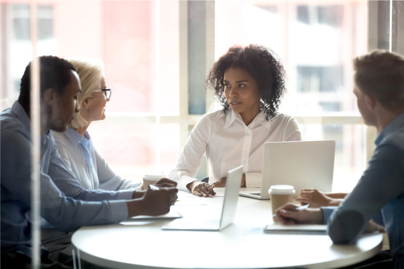 Married couple at desk speaking with 3 people